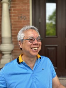 Portrait of Aloysius Siow in front of the Department of Economics, UofT 