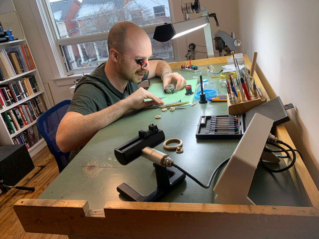 John Cairncross repairs a pocket watch in his home workshop. 