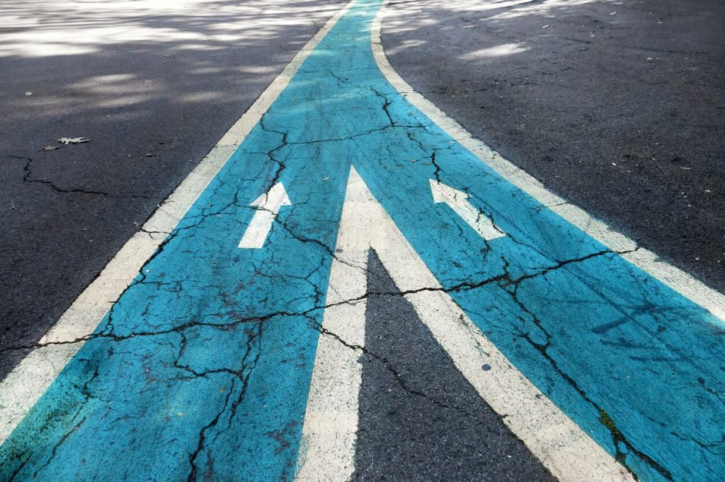 A road way with a convergence bringing together two lanes. 