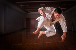 A student student performs a mid-air karate move. 